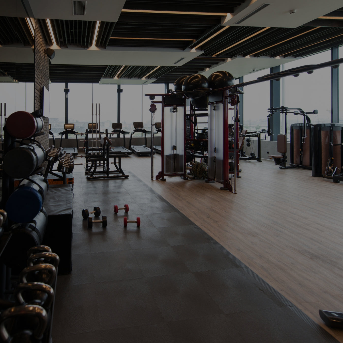 Gym interior with various equipment including weights and machines.